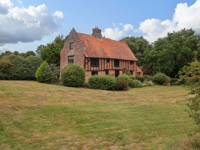 A house surrounded by grass and trees at Keirs Cottage Carlton Colville