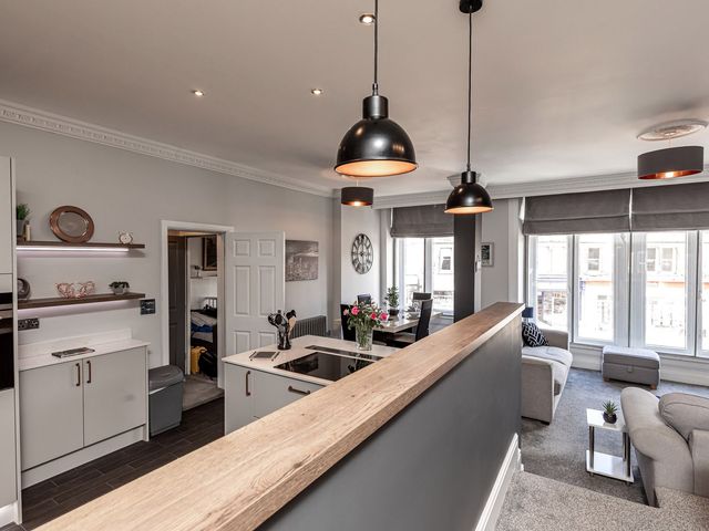 A living room with a kitchen and seating area at The Crows Nest in Buxton