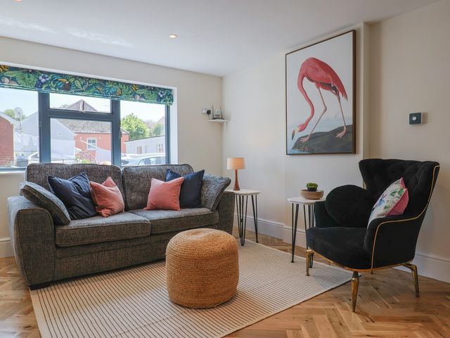 A living room with a sofa and armchair at 1 Mill Green Court Lyme Regis