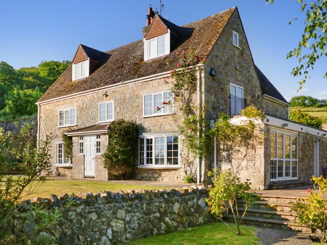 A house with stone exterior and garden at Tuckers Farm in Gatcombe