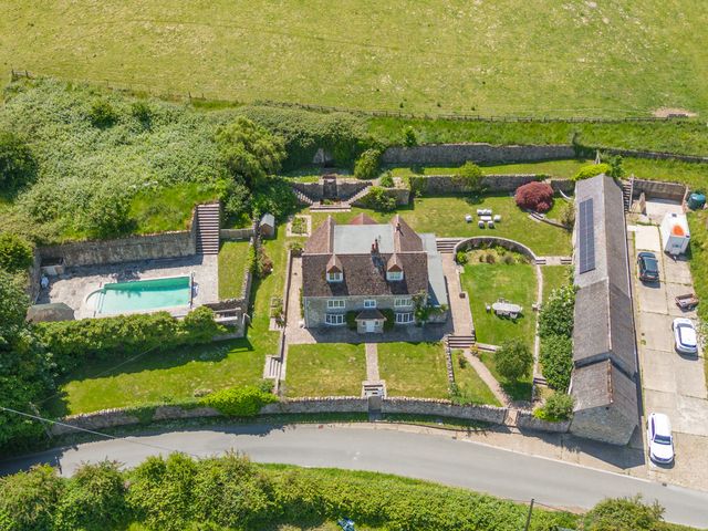 An aerial view of a house with a swimming pool and garden at Tuckers Farm in Gatcombe