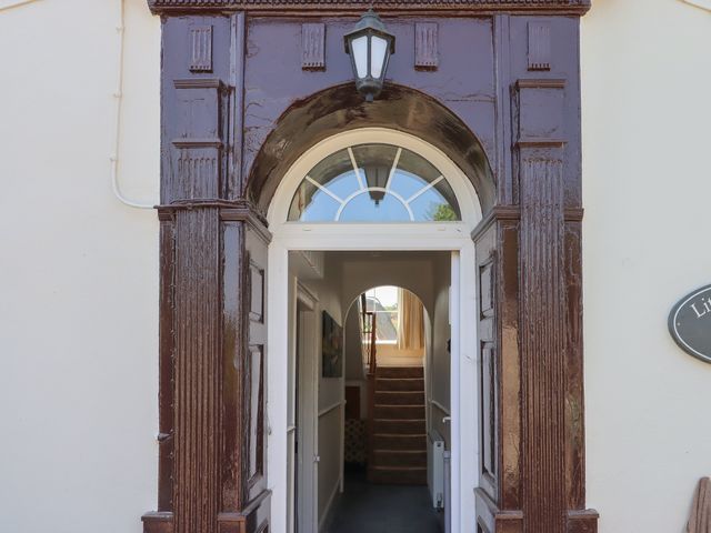 An entryway with a staircase and light fixture at Littleham Court Manor in Littleham near Bideford