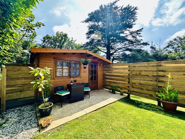 A garden shed with chairs and a table at Harvey's Lodge, Lowertown, Helston
