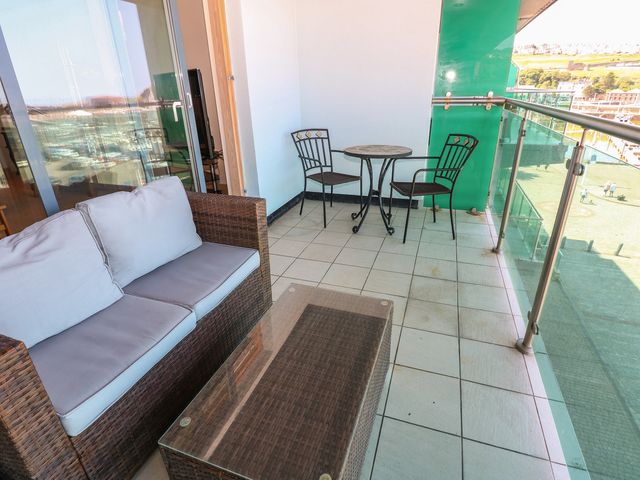 A balcony with a sofa and table at Pears Suite in Whitehaven