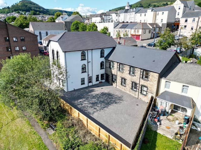 An outdoor view of a building and parking area at Tirpentwys Abertillery