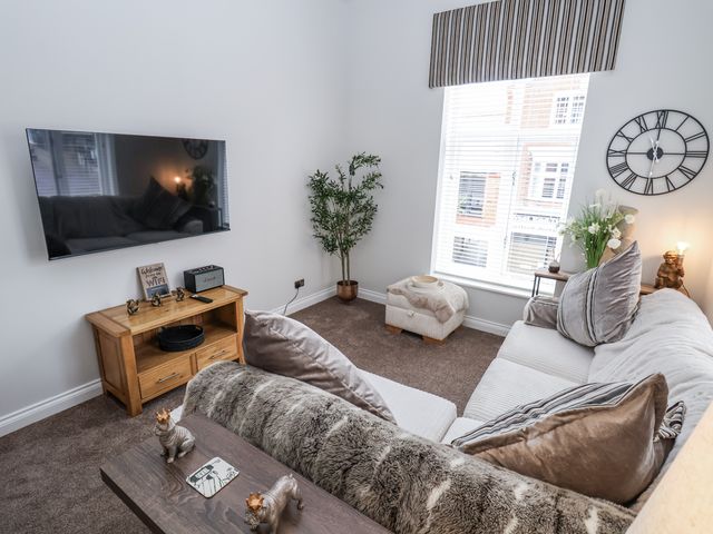 A living room with a sofa and television at No 2 Emporium Apartments in Prestatyn