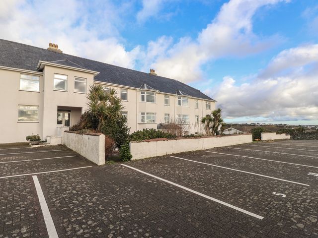 A building with windows and parking spaces at King Arthur Suite in Trearddur Bay
