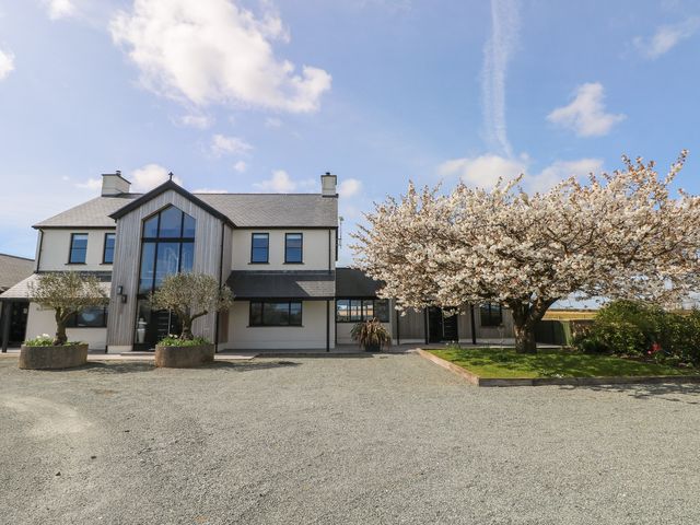 A house with a tree and parking area at Just A Cottage in St Florence