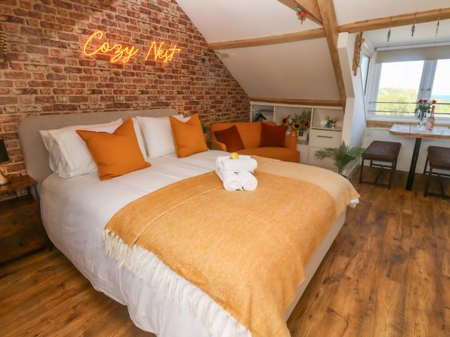 A bedroom with a bed and seating area at Seagulls Nest in St Ives