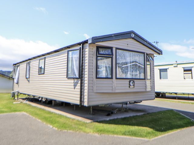 A caravan parked on a grassy area at V9 Ty Mawr Holiday Park