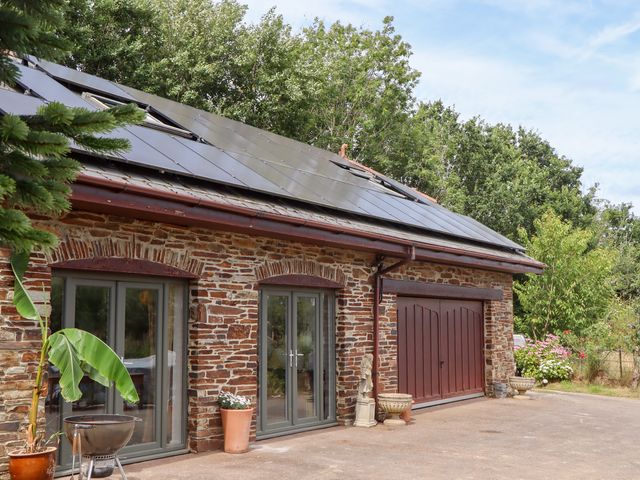 An outdoor view of a building with solar panels at Tigley Meadow Coach House in Totnes