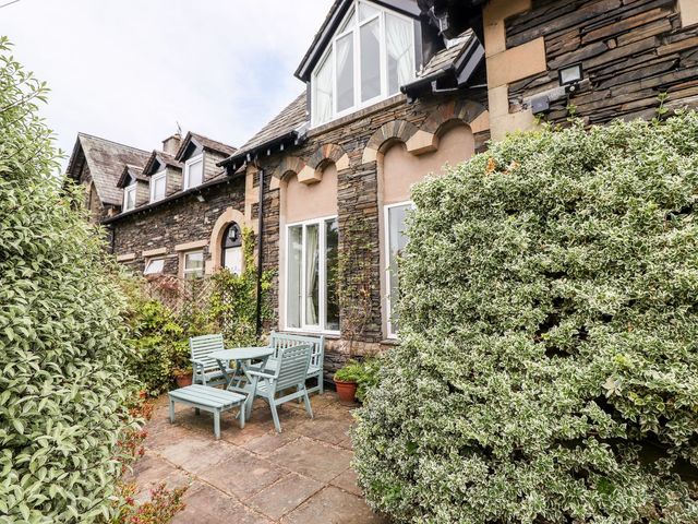 A garden with a table and chairs at School Cottage in Windermere