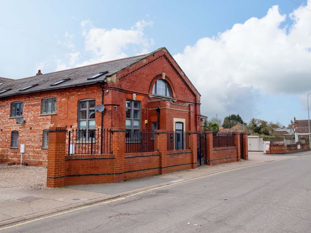 A brick building with a front fence and windows at 3 The Old Drill Hall Alford