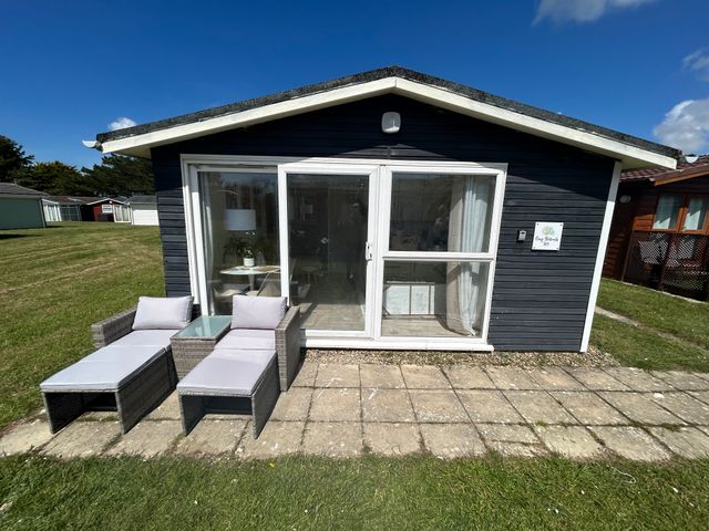An outdoor seating area in front of a cabin at The Old Barn in Padstow
