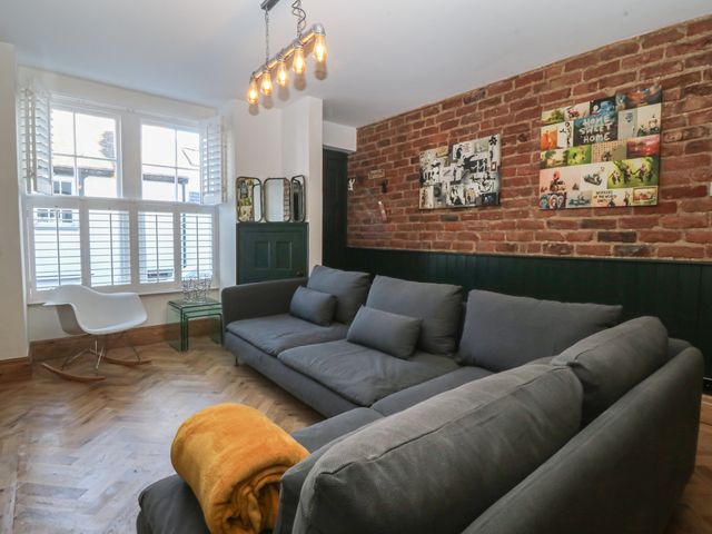 A living room with a sofa and chair at Ty Gelert in Conwy