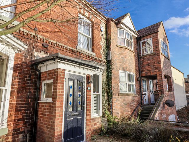 A brick house with a front door and multiple windows at 1 Castle Terrace