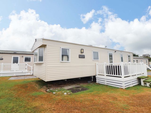 A caravan with steps and railings at Beachcombers Barmouth Bay Holiday Park Talybont