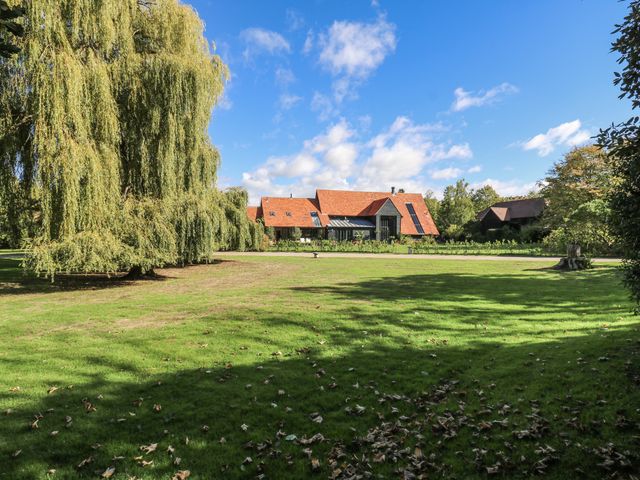 A house with a large garden surrounded by trees at Headland Barn in Maldon