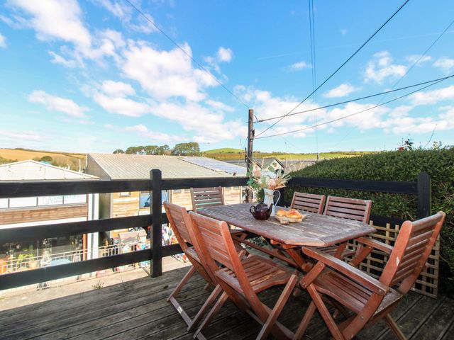 An outdoor seating area with a table and chairs at Rockside in Salcombe