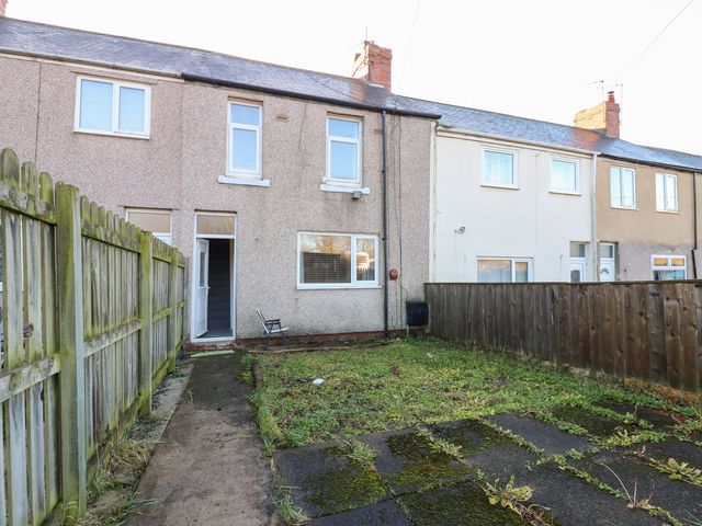 A backyard with a house and fence at 16 Salvin Terrace in Stockton-on-Tees