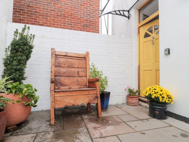 An outdoor area with a wooden chair and potted plants at Bohemian Beach Cottage in Bournemouth