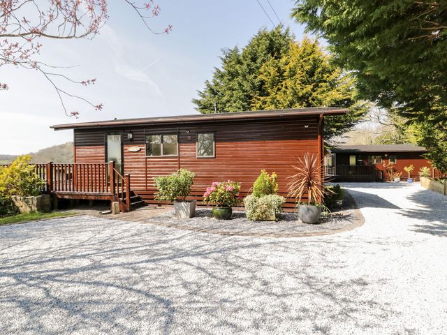 A cabin with a deck and plants at Summertime Lodge Rhyd-y-Foel near Abergele