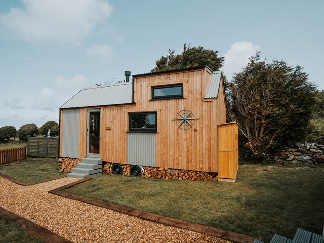 A tiny house with wooden exterior and steps at Rowan in Carreglefn near Llanfechell