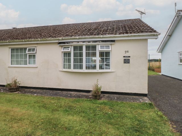 An exterior view of a bungalow with a front yard at Chalet 26 in Scurlage