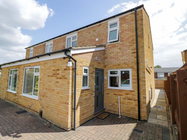 An exterior view of a brick house with windows and a pathway at 22 Old Chapel Close in Kidlington