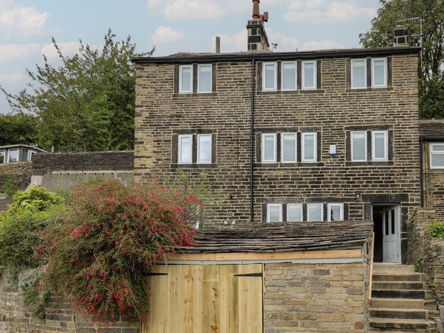 A house with multiple windows and a door at 6 Well Hill in Holmfirth