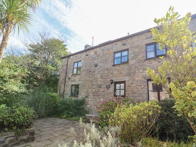 A stone house with plants and a pathway at Mill House Barn 