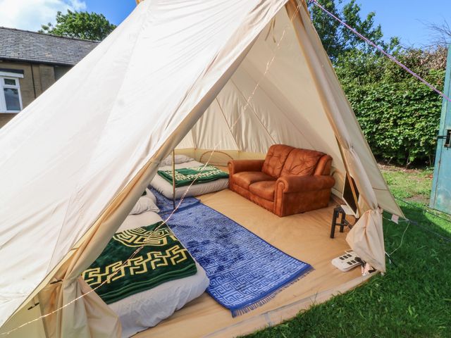 A tent with a sofa and beds at Bell Tent Three