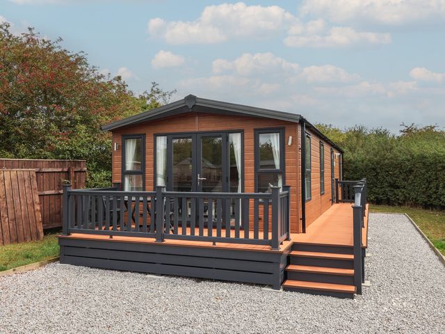 A cabin with a deck and steps at Meadows Park 1 Great Hatfield near Hornsea