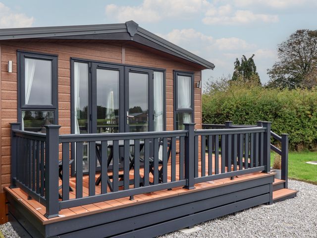 A house with a deck and railing at Meadows Park 1 Great Hatfield near Hornsea