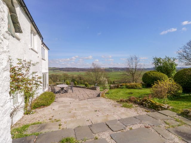 An outdoor view of a patio area with a table and chairs at Barn Howe Lyth near Levens