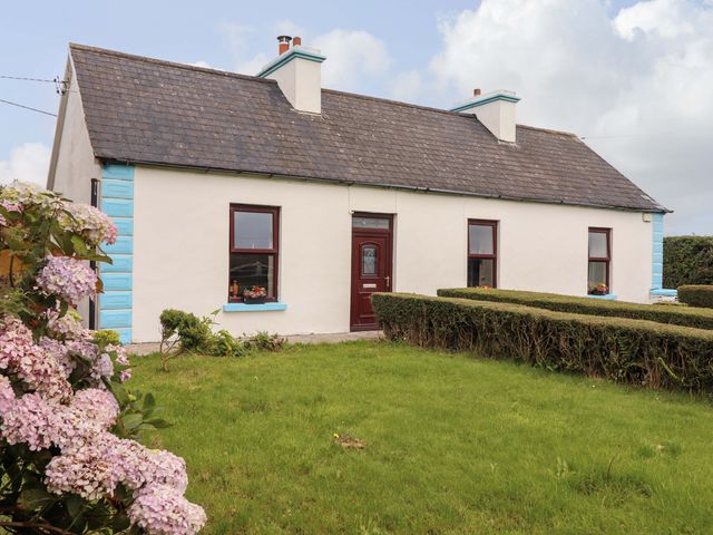 A house with windows and a door surrounded by a garden at The Farmhouse in Tralee, County Kerry