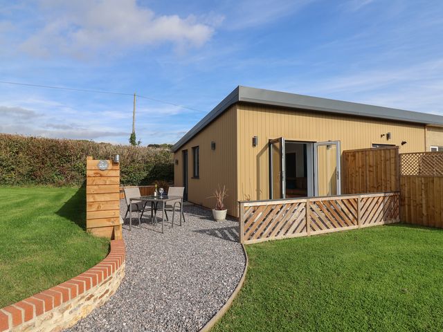 An outdoor seating area with table and chairs at The Roost in Whitford Nr. Colyton