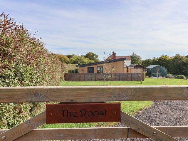 An outdoor area with a gate and house view at The Roost Whitford Nr. Colyton