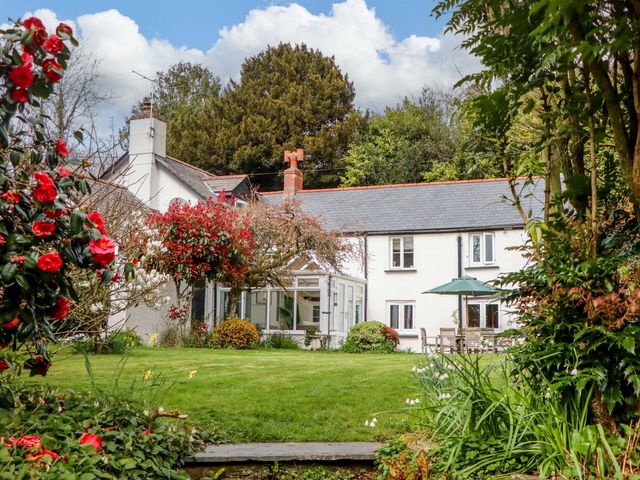A garden with a house and patio furniture at Town Farm Cottage in Barnstaple