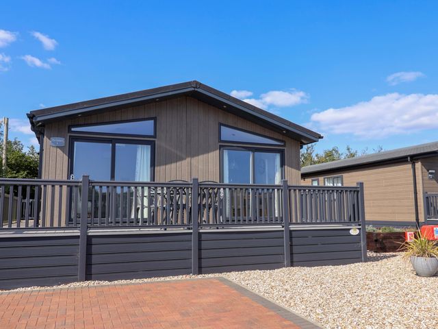 A house with decking and fence at Cedar 1 Pinewood Retreat in Rousdon near Lyme Regis