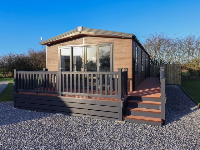 A cabin with a deck and steps at Meadows Park 3 Great Hatfield near Hornsea