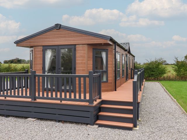 An outdoor area with a cabin and deck at Meadows Park 4 Great Hatfield near Hornsea