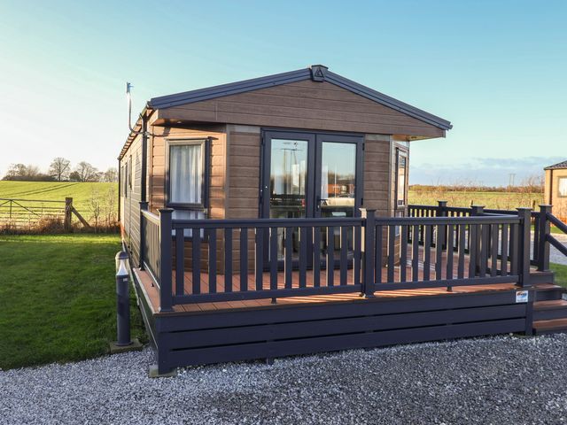 A mobile home with deck and railing at Meadows Park 4 Great Hatfield near Hornsea