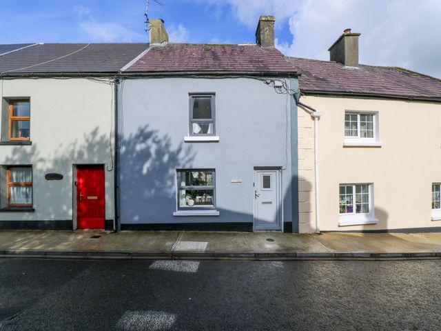 A house with a red door and windows at Rose Cottage, Killala, County Mayo