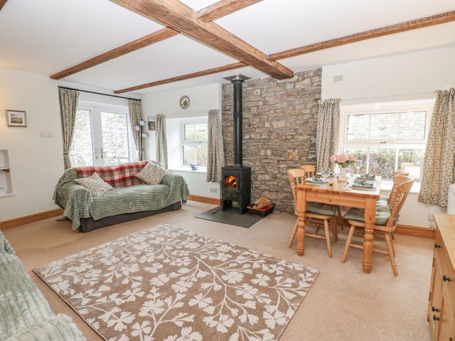 A living room with a sofa and wooden table at 1 Mill Cottage (known as Old Mill 1) Askrigg near West Burton