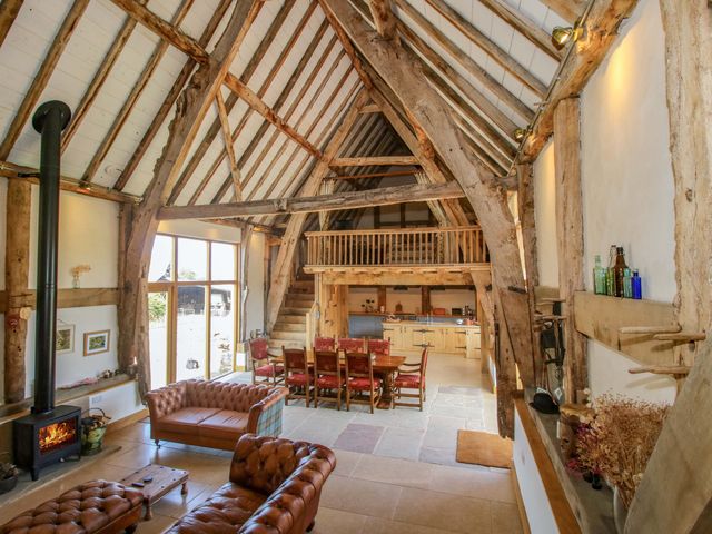 A living room with a sofa and dining area at Crook Barn in Tenbury Wells
