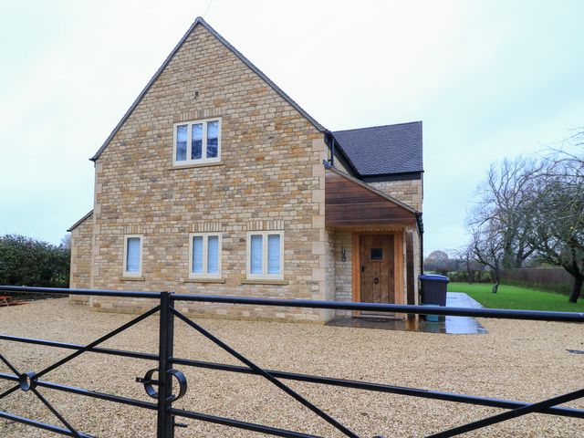 A house with stone walls and windows at Peewit Coach House in Moreton-in-Marsh