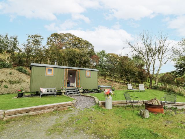 A shepherd's hut with outdoor seating and greenery at Brondel Luxury Shepherd's Hut in 