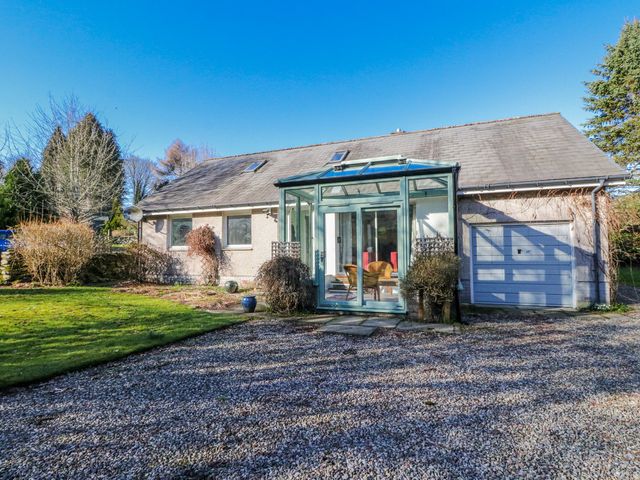 A house with a glass conservatory and garage at Grianach in Balnaguard near Strathtay