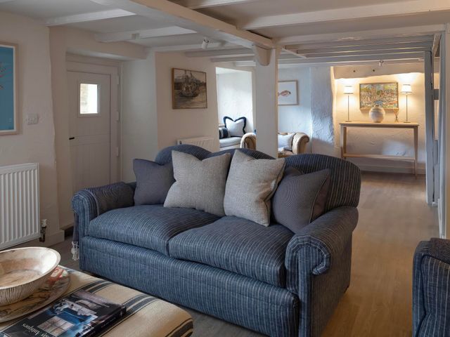 A living room with a sofa and artwork at Rose Cottage in Wadebridge
